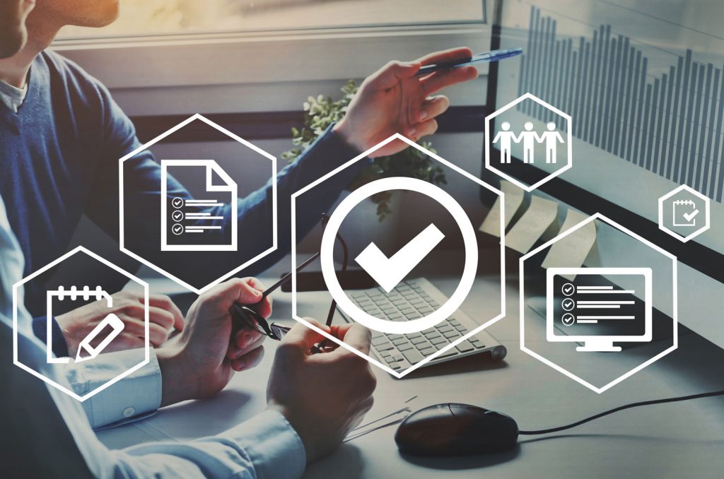 two staffs sitting in front a computer screen looking at data representing corporate services Melchers Taiwan